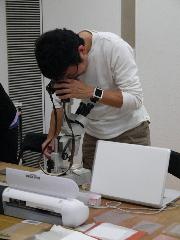 画像　顕微鏡で版を拡大して写真を撮る久保田さん