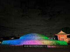 七色にライトアップされた古墳の写真