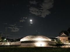 ライトアップされた古墳と月の写真