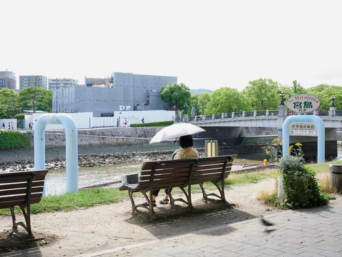 公園のベンチに座る女性の写真