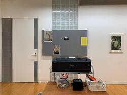 プリンターと壁に貼られた作品