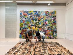 作品を繫ぎとめていたビスを抜く栗原さんと助手さん