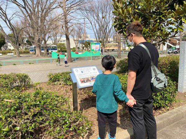 画像　郷土の森総合体育館の銘板を見る市民