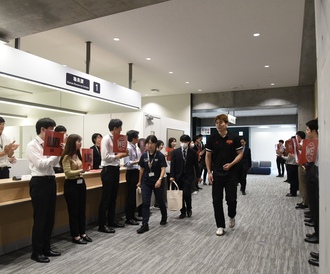 アルバルク東京の出席者が庁内を歩いて会議室に向かわれる写真