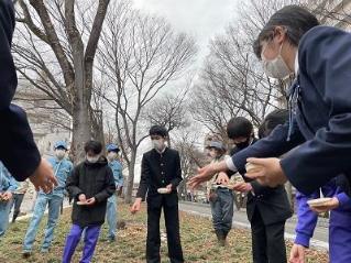 画像　農業高校の皆さん（後ろ）のサポートによる種まき