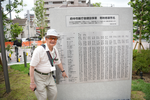 銘板と記念撮影をする寄附者の画像